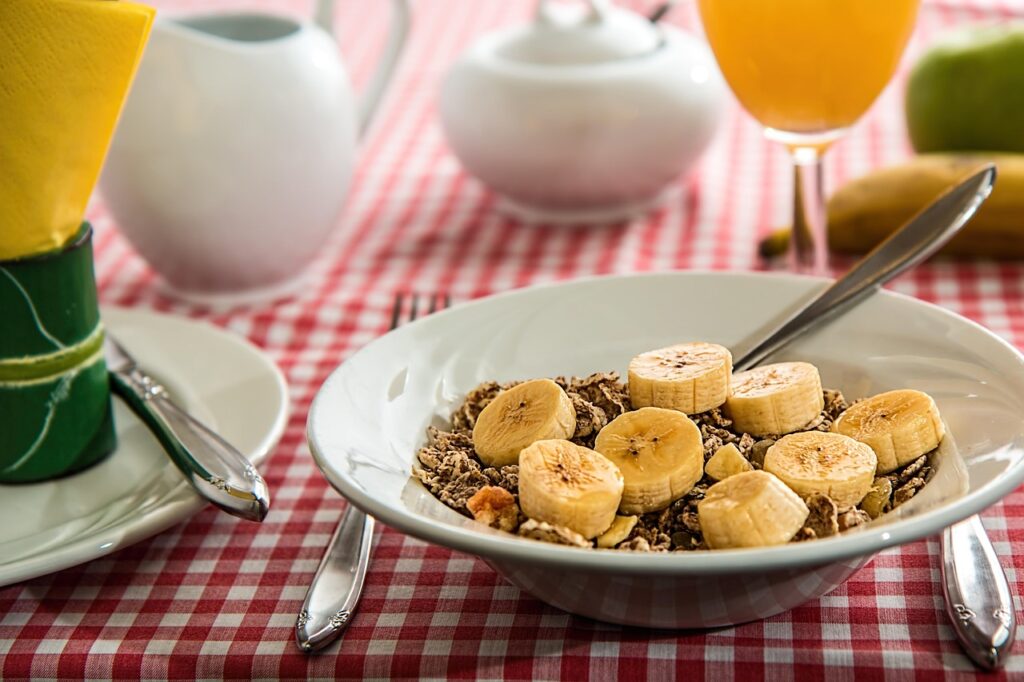 Fresh banana smoothie and fruit bowl with mango and dates
